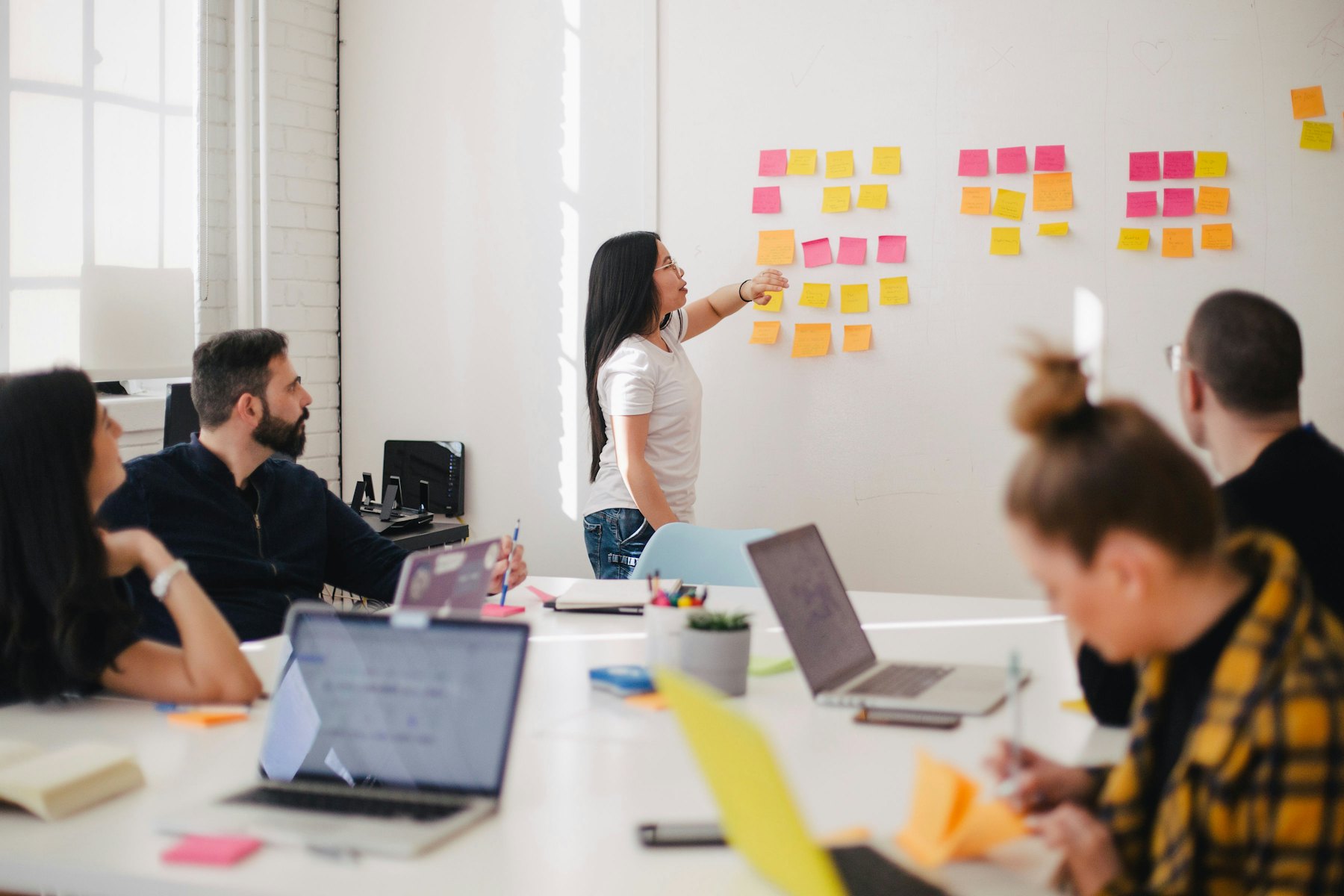 Team reviewing service signals on a whiteboard in a bright meeting room